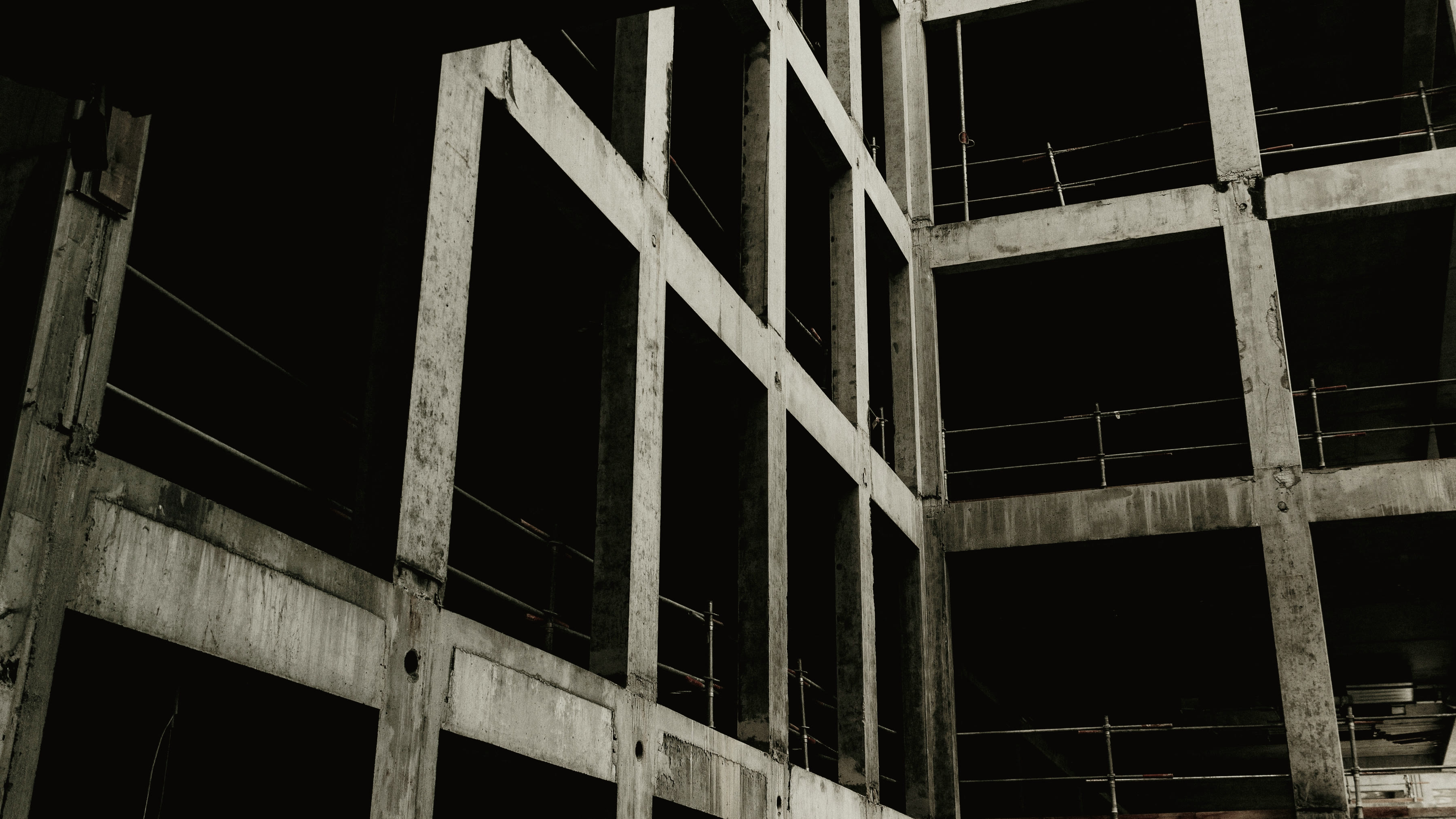 An unfinished reinforced-concrete frame, its bays open to the weather.