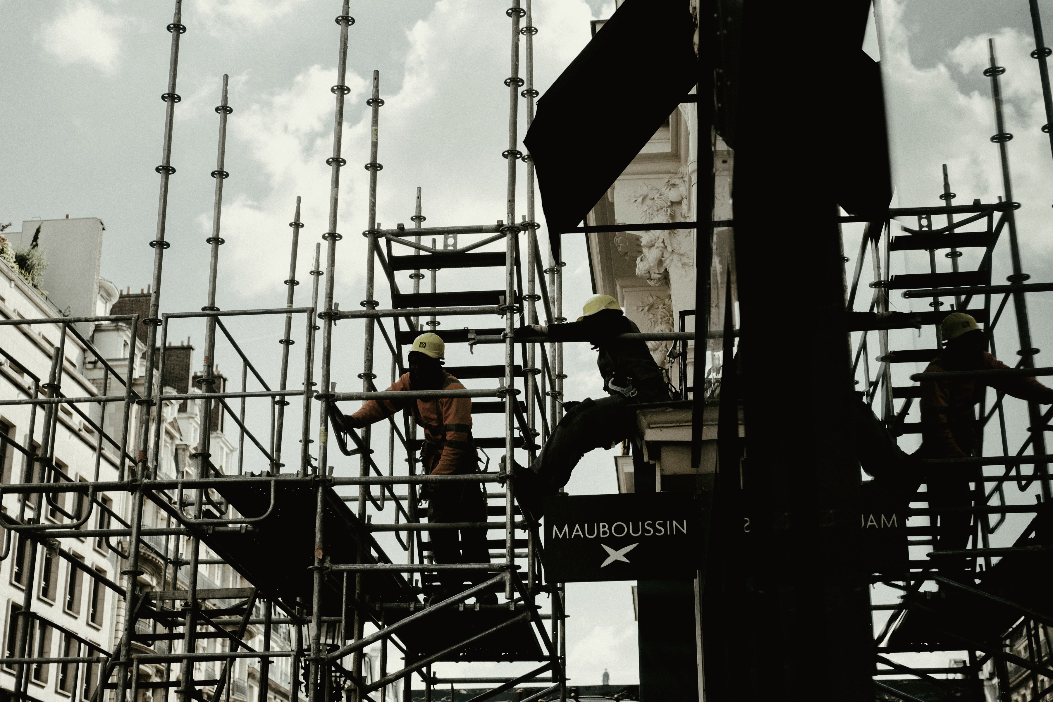 Multiple trades working at once across a crowded structural frame.