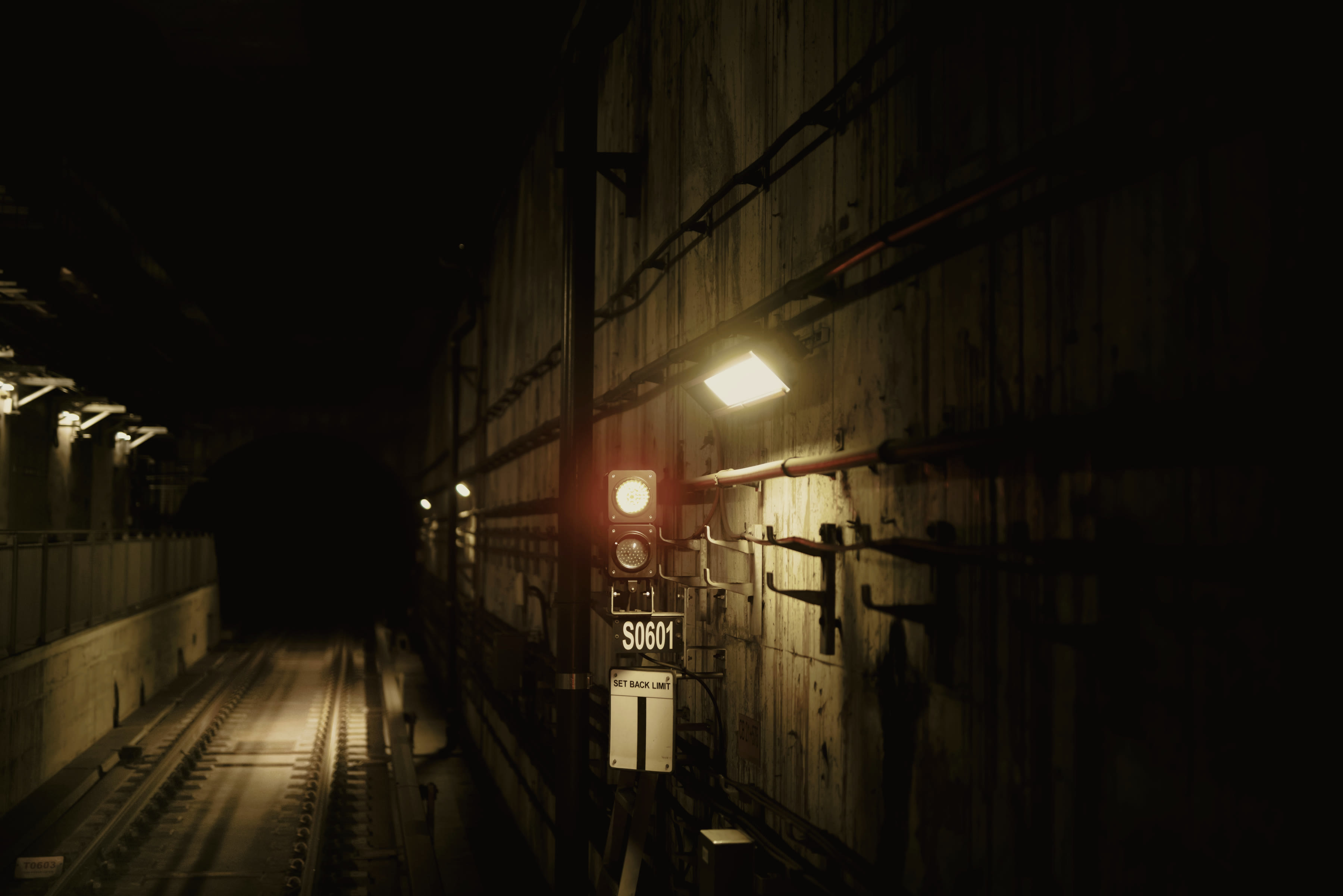A long concrete service tunnel receding into shadow